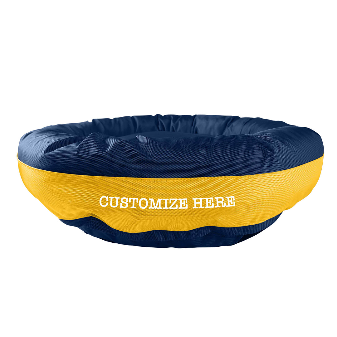 Navy round bolstered dog bed with yellow band in the middle with white embroidered 'Customize Here'.