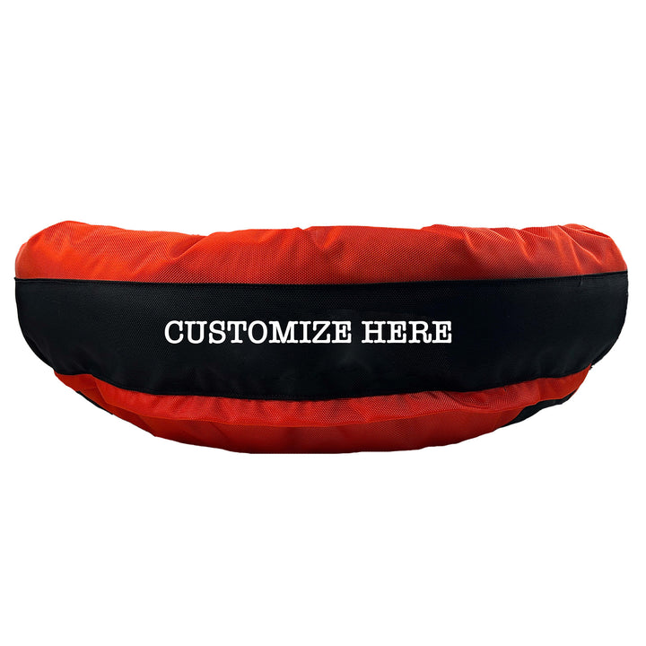Orange round bolstered dog bed with black band and white embroidered 'Customize Here'.