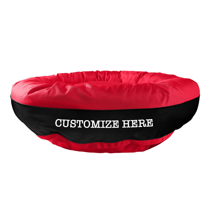 Red round bolstered dog bed with a black band and white embroidered 'Customize Here'.