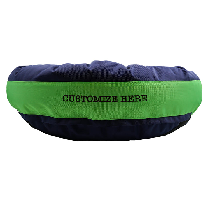 Navy round bolstered dog bed with a green band and blue embroidered 'Customize here'.