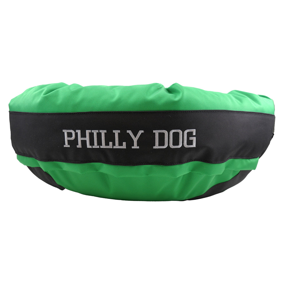 Green round bolstered dog bed with a black band and white embroidered 'Philly Dog'.