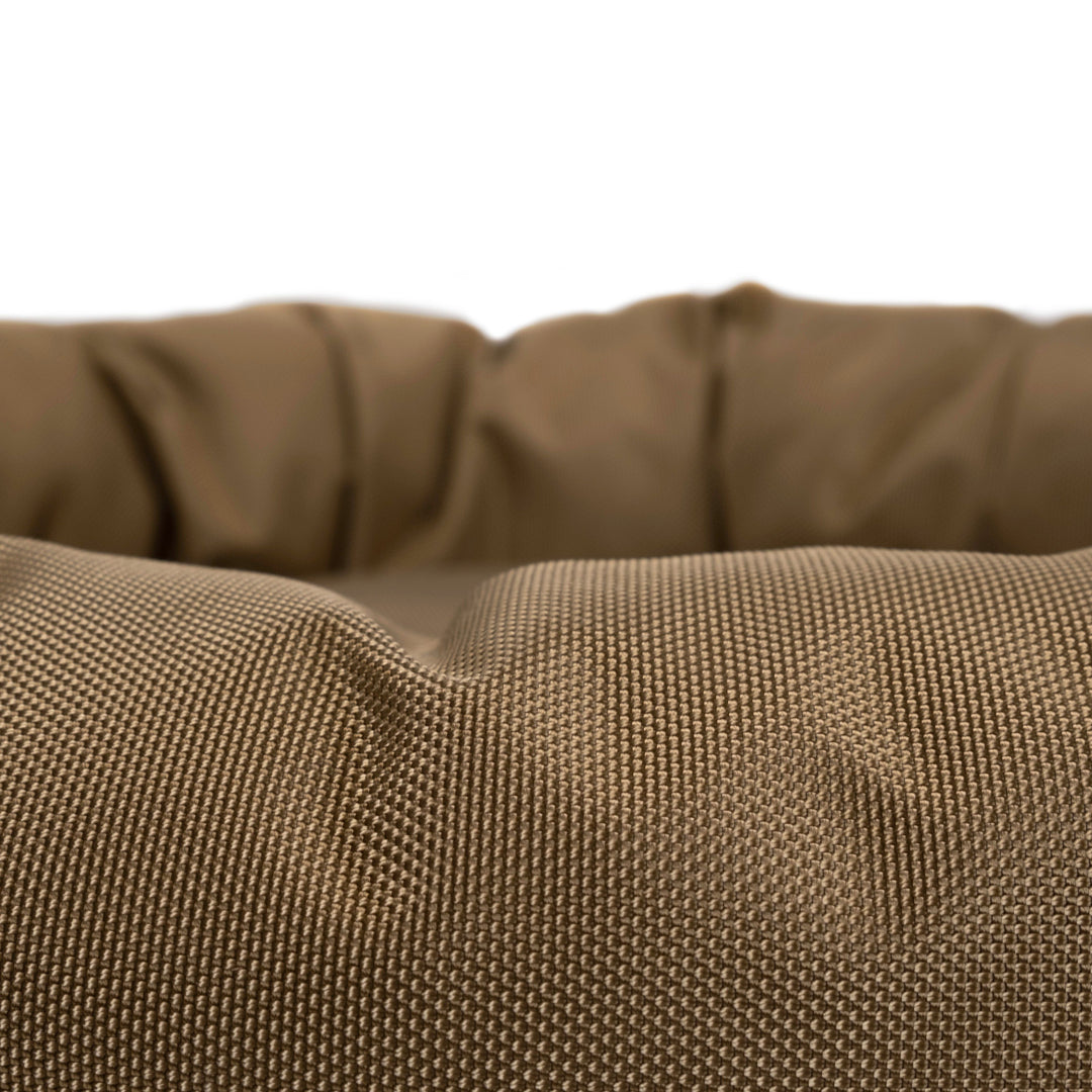 Round coyote bolster bed close up showing texture