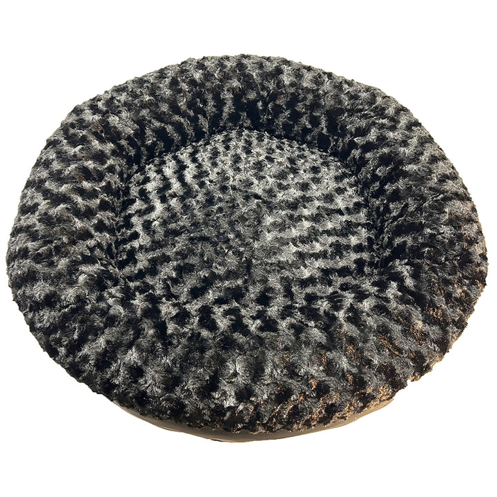 Round bolstered dog bed with textured black fleece surface on a white background