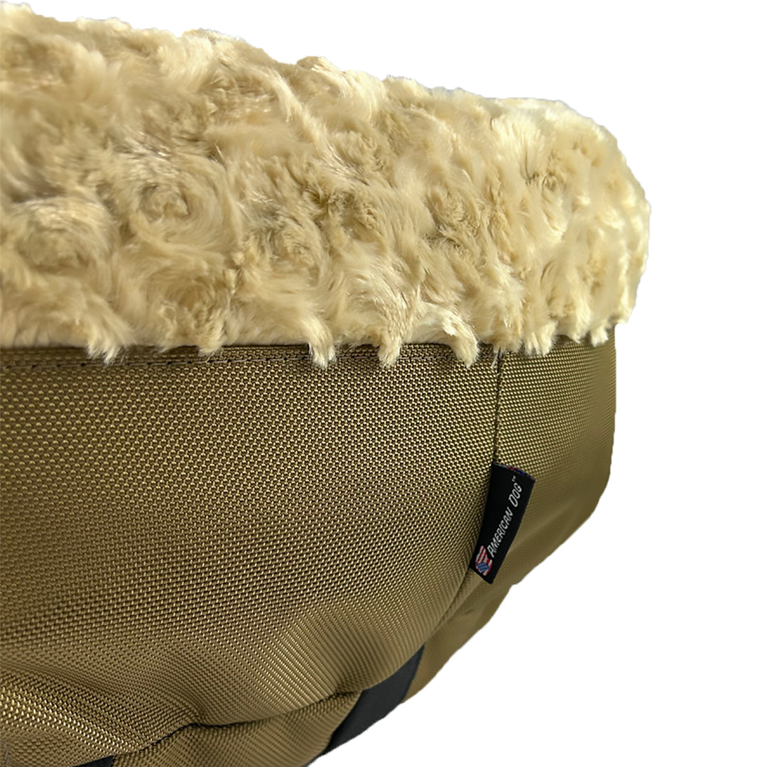 Camel colored dog bed with fluffy top and textured sides on a white background