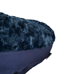 close up of dark blued fleece bolstered round dog bed 