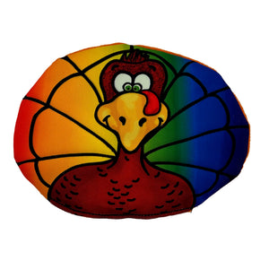 Oval shaped dog toy with a cartoon of turkey with a rainbow background