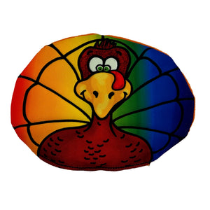 Oval shaped dog toy with a cartoon of turkey with a rainbow background