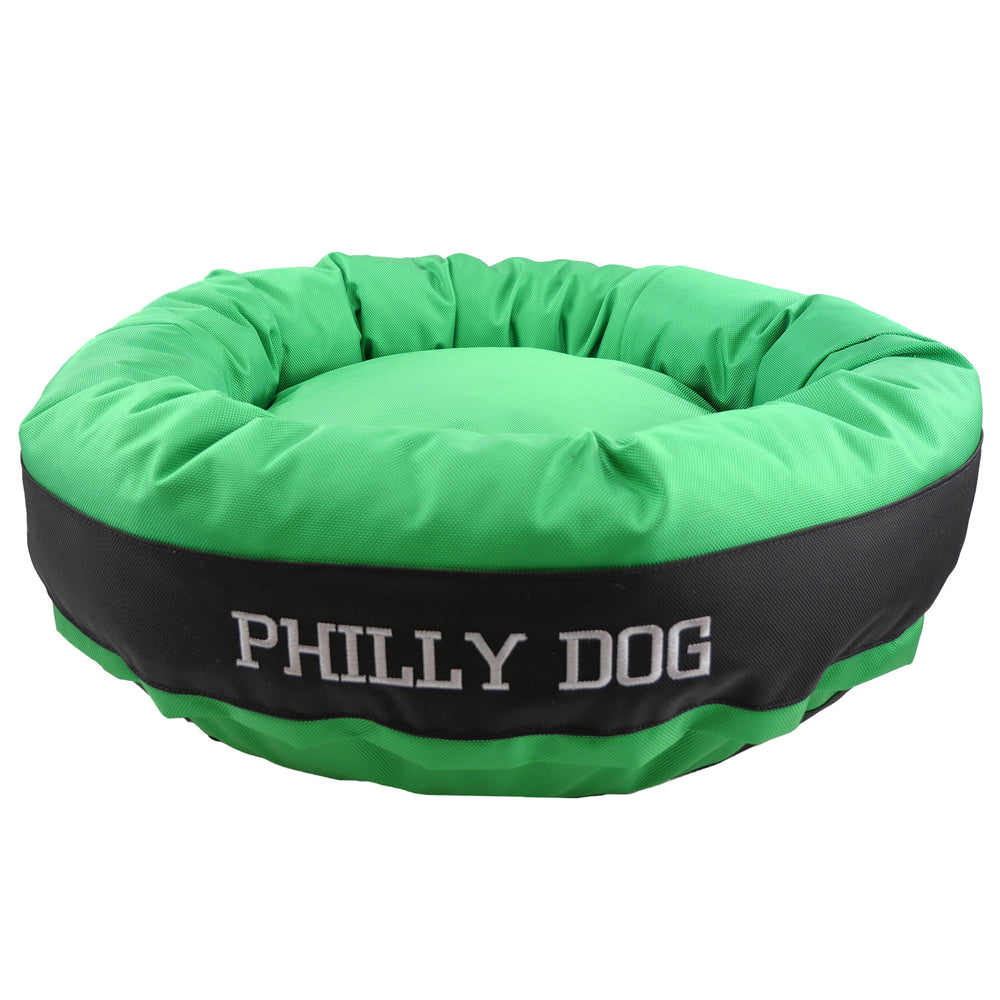 Green round bolstered dog bed with a black band and white embroidered 'Philly Dog'.