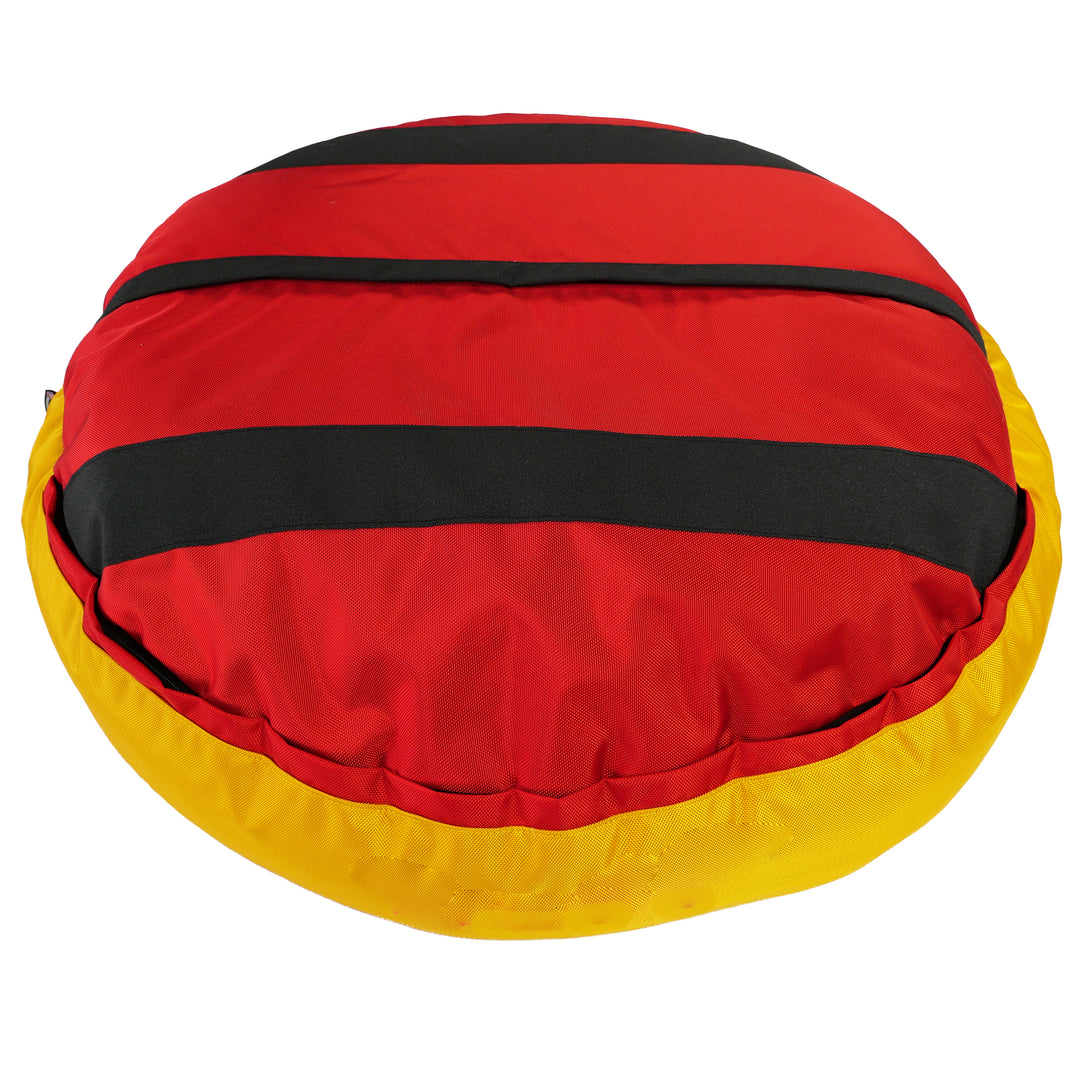 Bottom of red round bolstered dog bed with black strips and yellow band.