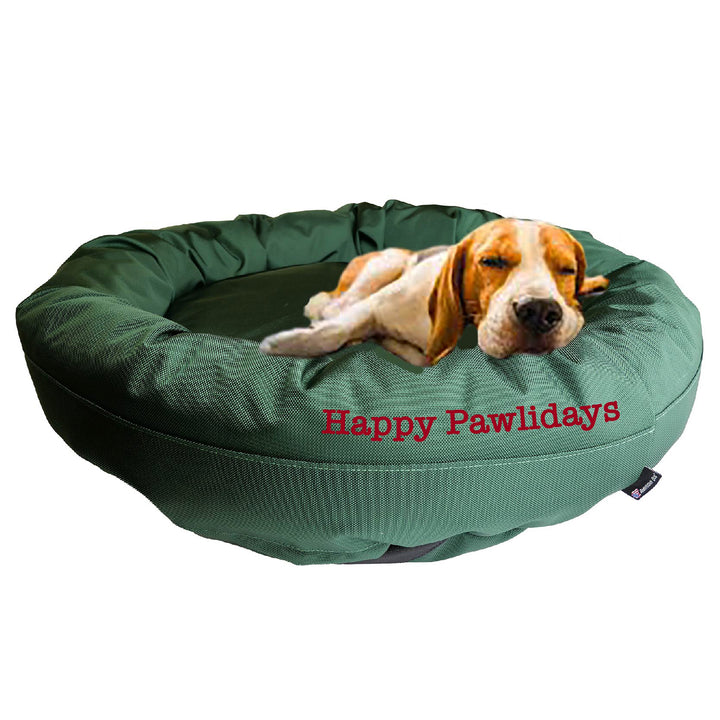 Dark Green round bolstered dog bed with a Beagle  laying in it with 'Happy Pawlidays' embroidered on the side.