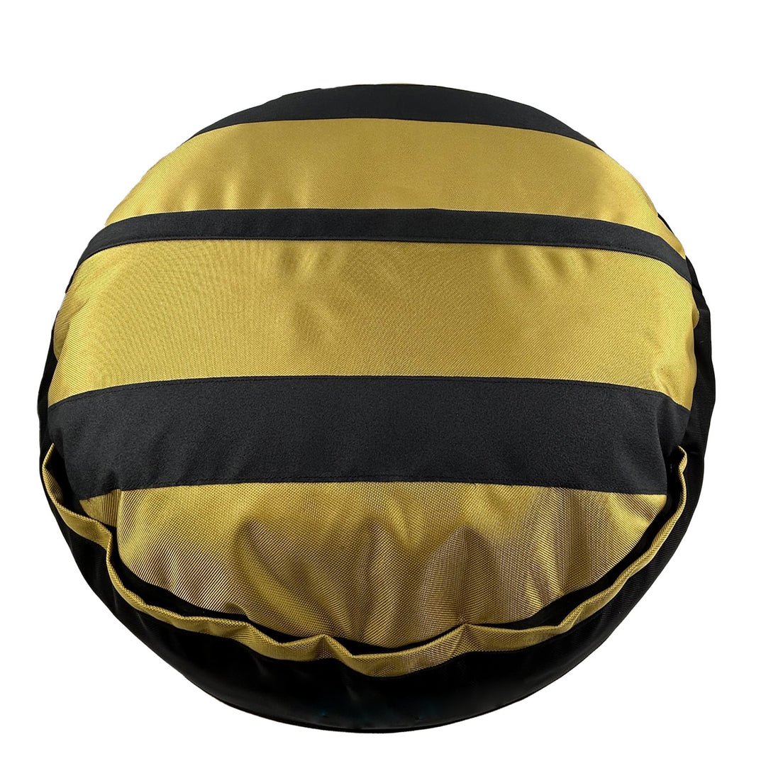 Bottom of a gold round bolstered dog bed with black strips and black band.