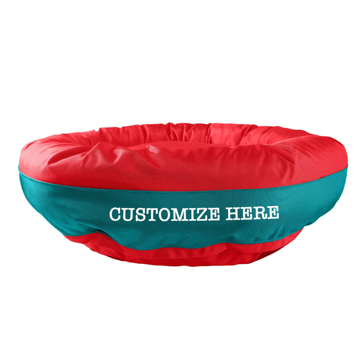 Orange round bolstered dog bed with a teal band and white embroidered 'Customize Here'.