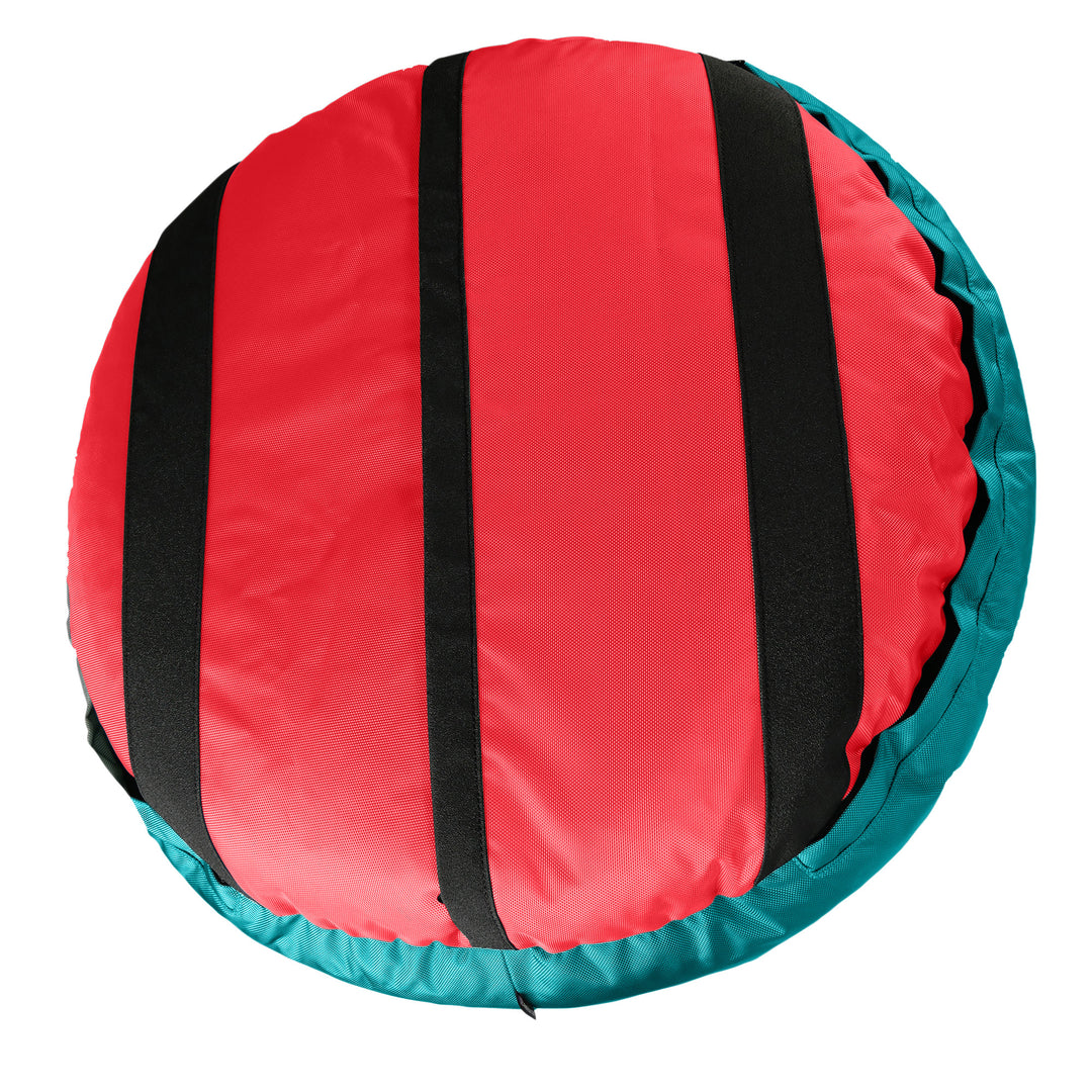Bottom of an orange round bolstered dog bed with black strips and teal band.