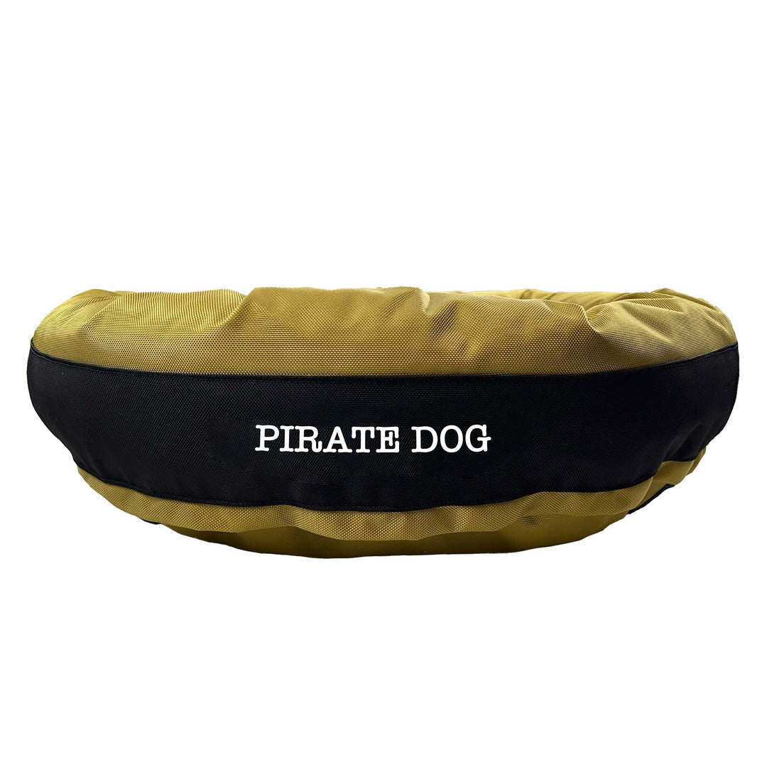 Gold round bolstered dog bed with a black band and white embroidered 'Pirate Dog'.