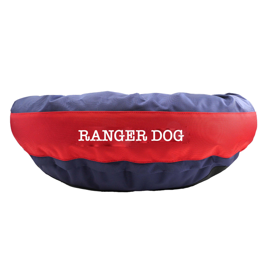 Blue round bolstered dog bed with a red band and white embroidered 'Ranger Dog'.