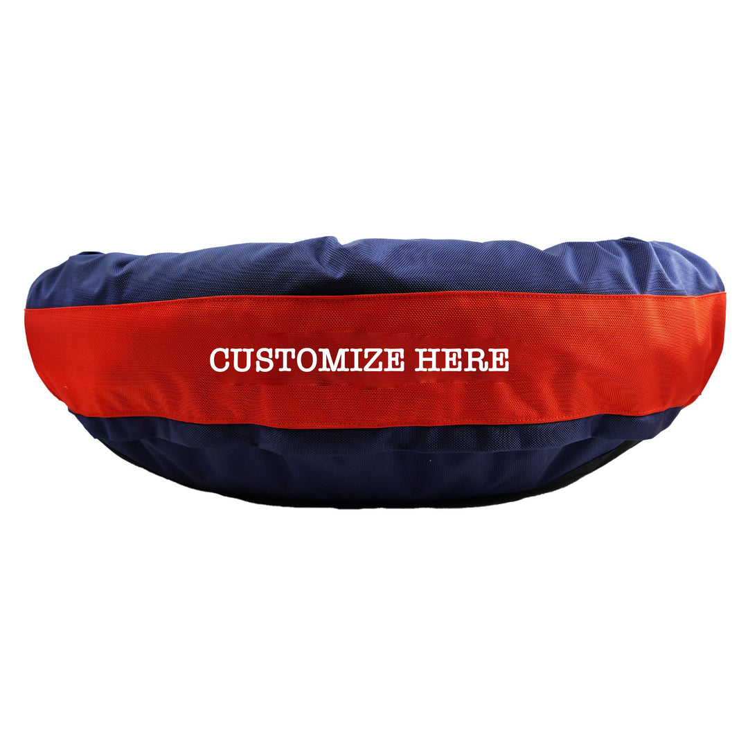 Navy round bolstered dog bed with an orange band and white embroidered 'Customize Here'.
