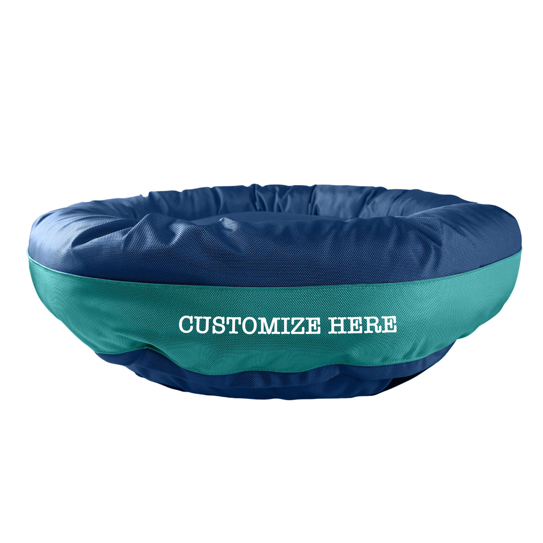 Navy round bolstered dog bed with a teal band and white embroidered 'Customize Here'.