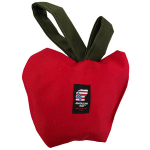 Red apple shaped dog toy with green loops on top to tug with
