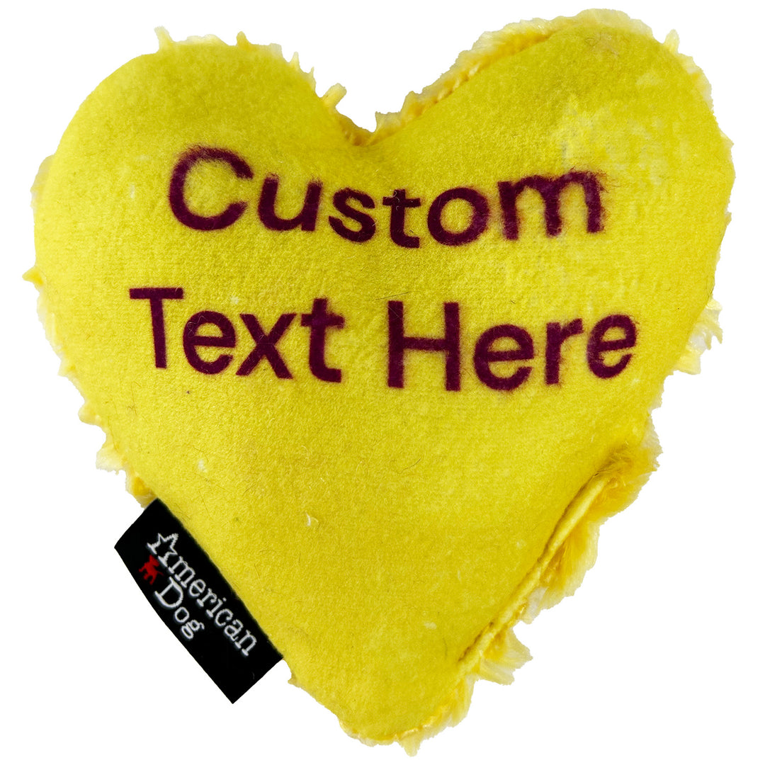 Yellow heart-shaped dog toy with customizable text and American Dog branding.