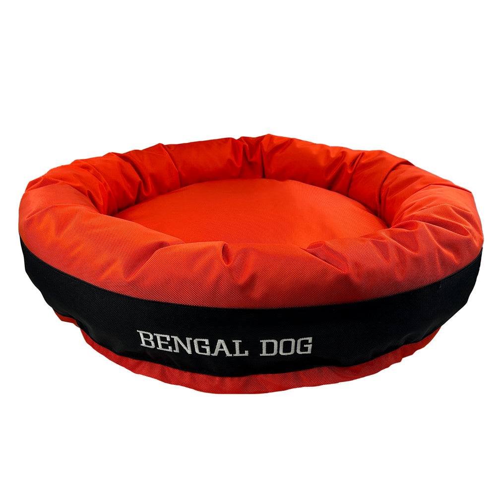 Orange round bolstered dog bed with an orange band and white embroidered 'Bengal Dog'.