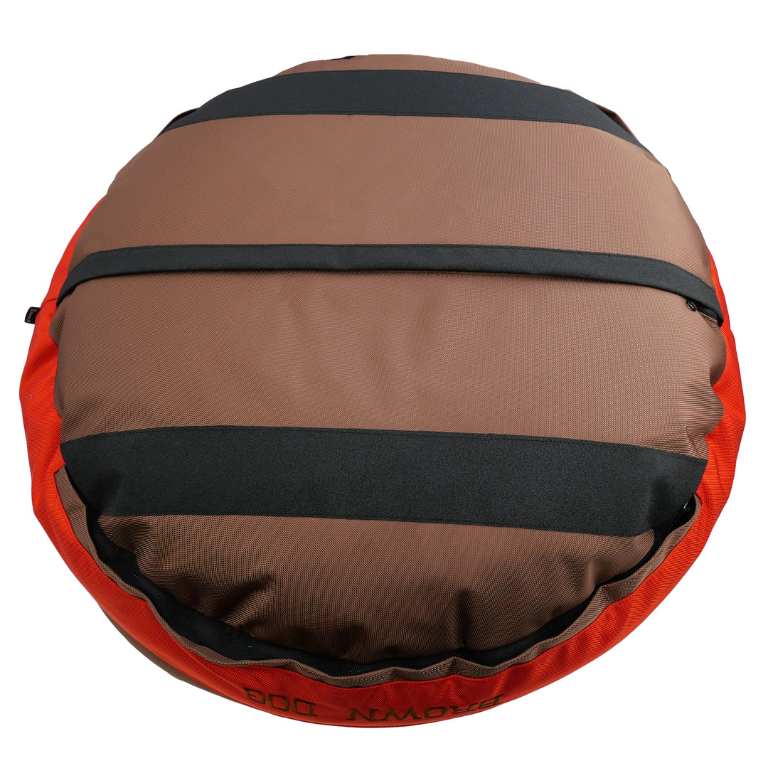Bottom of a brown round bolstered dog bed with black strips and an orange band.