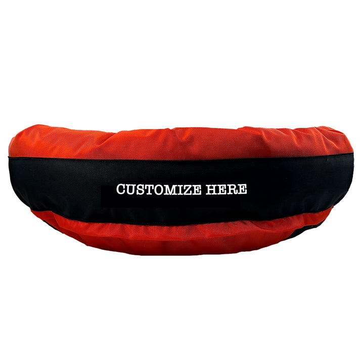 Orange round bolstered dog bed with an orange band and white embroidered 'Customize Here'.