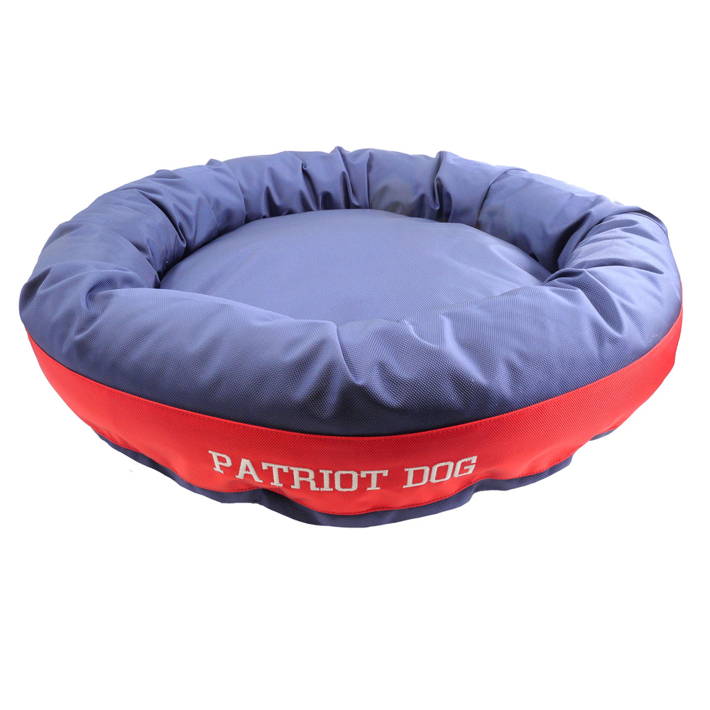 Bue and red round bolstered dog bed with 'Patriot Dog' embroidered on the side