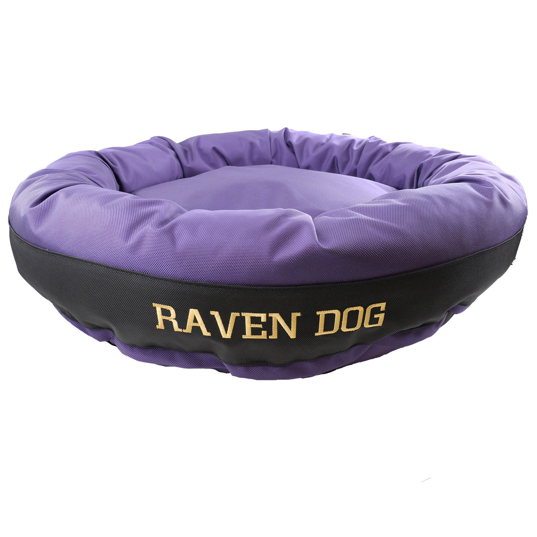 Purple and black round bolster dog bed with gold 'Raven Dog' embroidered on the side