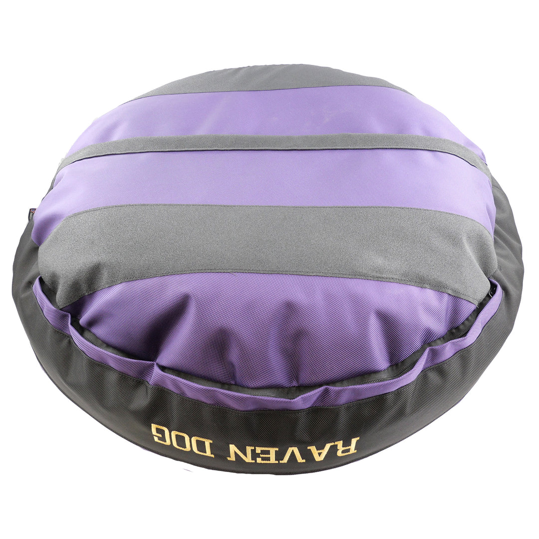 Bottom view of round bolster purple dog bed with black stripes