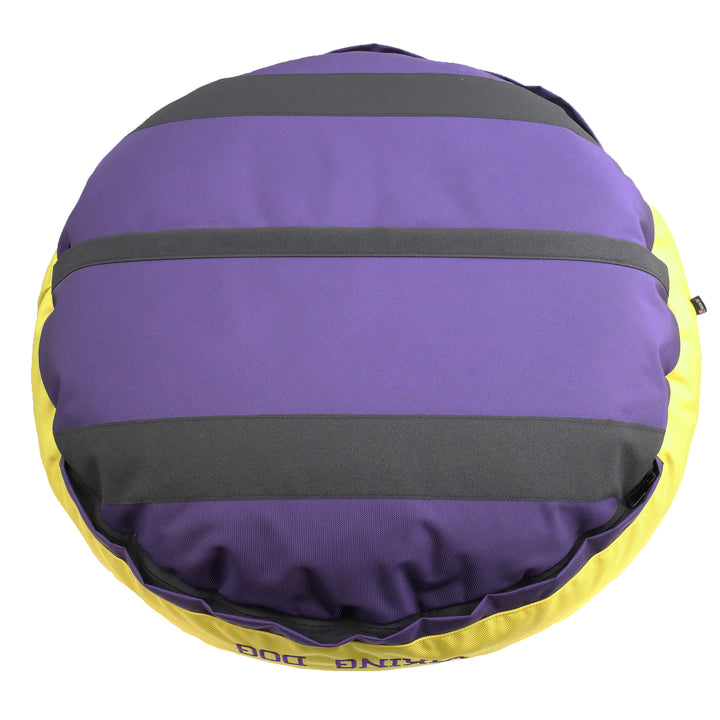 Bottom of purple round bolstered dog bed with black strips and yellow band.