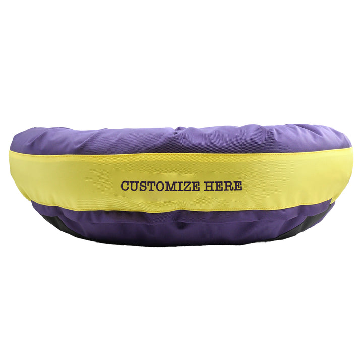 Purple round bolstered dog bed with yellow band and purple embroidered 'Customize Here'.