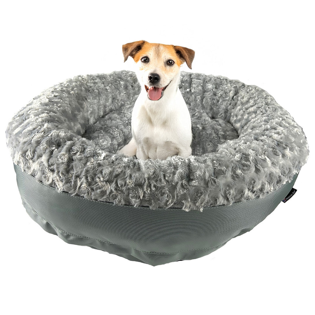dog sitting on a silver fleece round bolstered dog bed