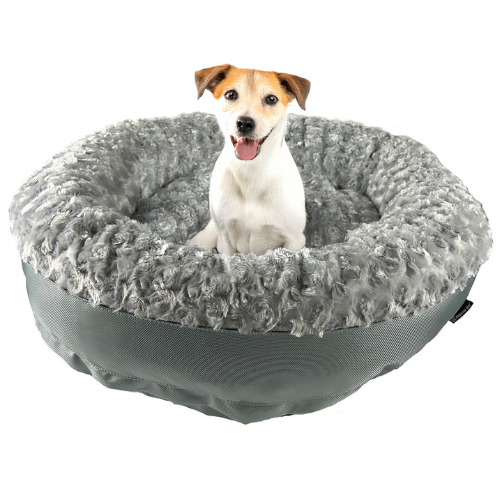 dog sitting on a silver fleece round bolstered dog bed