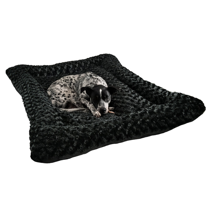 Black rectangle bolstered  fleece dog bed with a spotted dog laying on it