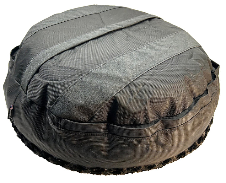 Round fuzzy black bolster bed back side showing grip strips